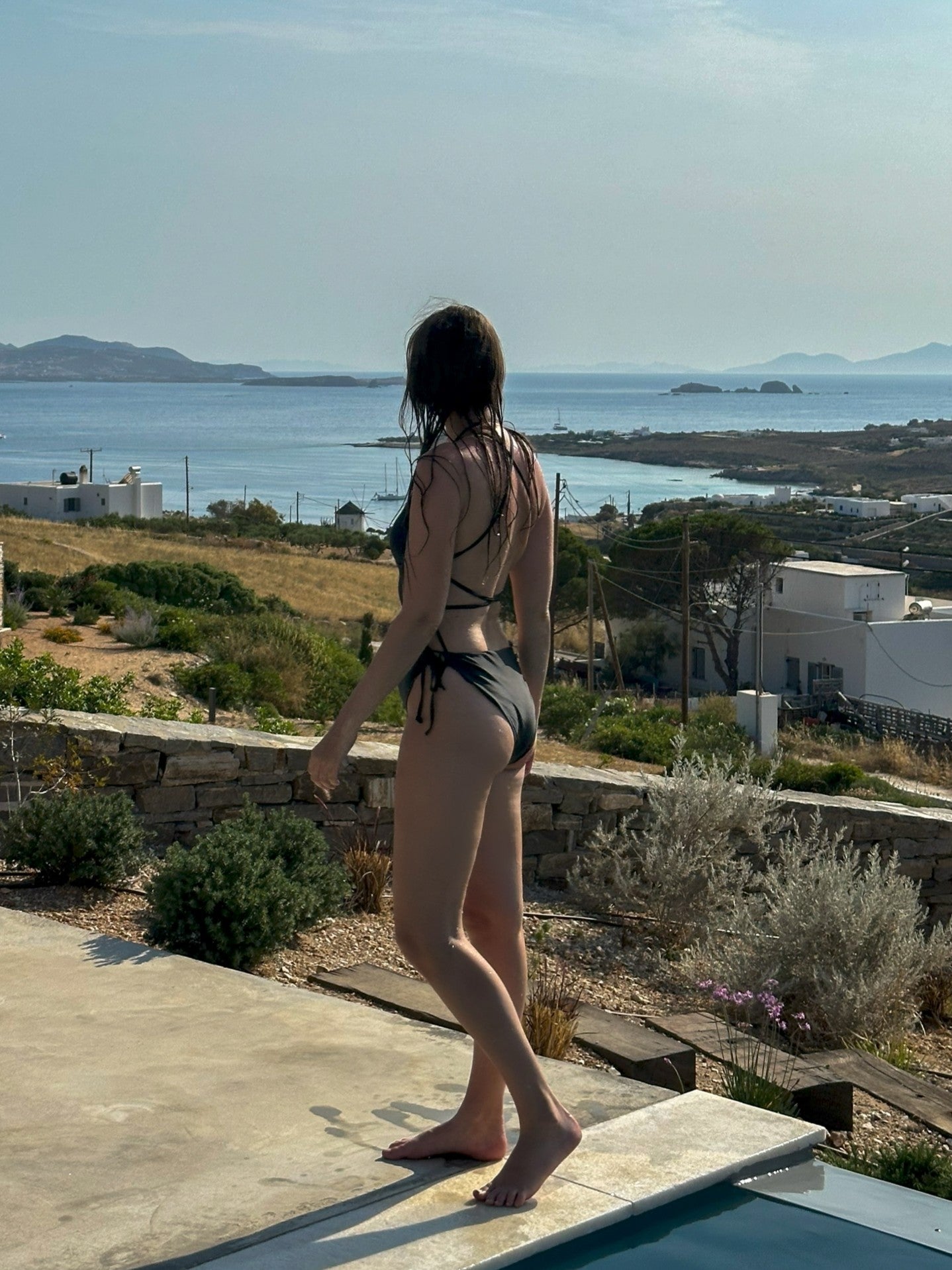 ESAMY The Twist Criss-Cross One-Piece Swimsuit in Black - Beach Lifestyle Back View with Open Back and Criss-Cross String Ties